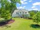Expansive front lawn enhances this gray painted brick home with mature landscaping and large picture windows at 6208 Old Miravalle Ct, Raleigh, NC 27614