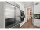 Kitchen showcasing stainless steel refrigerator and double ovens with hardwood floors that lead to the butler's pantry at 6208 Old Miravalle Ct, Raleigh, NC 27614