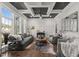 This living room boasts large windows, coffered ceilings, and elegant furnishings, creating a warm and inviting space at 6208 Old Miravalle Ct, Raleigh, NC 27614