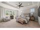 Spacious bedroom featuring a tray ceiling, large windows, and a cozy sitting area at 6208 Old Miravalle Ct, Raleigh, NC 27614