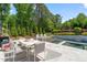 Charming backyard with a modern pool, outdoor seating, a dining area, and lush landscaping for serene relaxation at 6208 Old Miravalle Ct, Raleigh, NC 27614