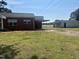 Rustic brick house with a car port near a large field and outbuildings at 6555 Nc 58, Nashville, NC 27856