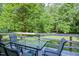 Back deck with seating overlooking a tree-filled backyard with a partial fence at 726 Thomas Rd, Rocky Mount, NC 27801