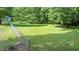 View from the deck of the large, grass backyard, and the wooded lot beyond the fence at 726 Thomas Rd, Rocky Mount, NC 27801