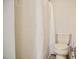 This bathroom features a toilet and a shower with a white shower curtain at 726 Thomas Rd, Rocky Mount, NC 27801