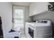 Functional laundry room with modern washer and dryer, storage cabinets, and natural light at 726 Thomas Rd, Rocky Mount, NC 27801