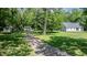 Lush lot with mature trees and a private driveway leading to the home at 726 Thomas Rd, Rocky Mount, NC 27801
