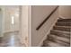 Carpeted stairway with a wooden handrail and view of the front door at 726 Thomas Rd, Rocky Mount, NC 27801
