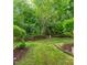 Private backyard with lush green lawn, mature shade trees and privacy landscaping at 7611 Satinwing Ln, Raleigh, NC 27617