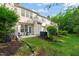 This home features a patio with seating and a lush green lawn and landscaping at 7611 Satinwing Ln, Raleigh, NC 27617