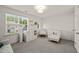 Bright, neutral Bedroom features a crib, rocking chair, dresser, and large window at 7611 Satinwing Ln, Raleigh, NC 27617