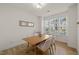 Sunny dining room featuring minimalist style, wood floors, and bright window at 7611 Satinwing Ln, Raleigh, NC 27617