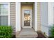 Townhome front entrance with a concrete walk-up and green foundation plants at 7611 Satinwing Ln, Raleigh, NC 27617