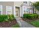 Charming townhome front entrance with a concrete walk-up and lush landscaping at 7611 Satinwing Ln, Raleigh, NC 27617