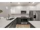 This kitchen showcases stylish two-tone cabinetry, stainless appliances, quartz countertops, and a trendy faucet at 7611 Satinwing Ln, Raleigh, NC 27617