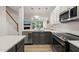 Well-lit kitchen features stainless steel appliances and dark lower cabinets at 7611 Satinwing Ln, Raleigh, NC 27617
