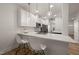 Modern kitchen features white cabinets, quartz countertops, stainless steel appliances, and a breakfast bar with seating at 7611 Satinwing Ln, Raleigh, NC 27617