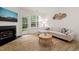 Cozy living room boasts a fireplace, white sectional, and lots of natural light at 7611 Satinwing Ln, Raleigh, NC 27617