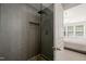 Sleek shower with tiled walls, pebble floor, a rainfall shower head, and built-in niche for storage at 7611 Satinwing Ln, Raleigh, NC 27617