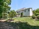 Spacious backyard featuring a lush lawn, mature trees, and a charming home exterior, perfect for outdoor enjoyment at 800 Skymont Dr, Holly Springs, NC 27540