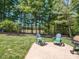 Lush backyard with a stone patio, perfect for outdoor seating and relaxation, surrounded by mature trees at 800 Skymont Dr, Holly Springs, NC 27540