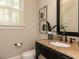 Granite countertop bathroom featuring wood cabinets, framed art, and modern fixtures at 800 Skymont Dr, Holly Springs, NC 27540
