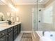 Modern bathroom with double sinks, granite countertops, large mirror, and a glass-enclosed shower at 800 Skymont Dr, Holly Springs, NC 27540