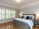 Relaxing bedroom with a king-size bed, hardwood floors, and large windows with plantation shutters at 800 Skymont Dr, Holly Springs, NC 27540