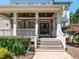 Inviting front porch with stone accents, white railings, and a welcoming entrance to the home at 800 Skymont Dr, Holly Springs, NC 27540