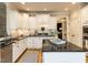 Well-appointed kitchen with white cabinets, black countertops, and a mosaic tile backsplash for a modern touch at 800 Skymont Dr, Holly Springs, NC 27540