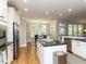 Open-concept kitchen with an island, stainless steel appliances, and a breakfast nook with shuttered windows at 800 Skymont Dr, Holly Springs, NC 27540