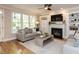 Bright living room with a fireplace, built-in shelves, and large windows overlooking the backyard at 800 Skymont Dr, Holly Springs, NC 27540
