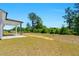 Large backyard featuring lush greenery, covered patio, and sunny lawn at 823 Biltmore Dr, Sanford, NC 27332