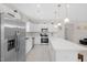 Modern kitchen boasts white cabinets, stainless steel appliances, a large island, and light wood flooring at 823 Biltmore Dr, Sanford, NC 27332