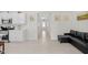 A bright kitchen with white cabinets is connected to a hallway and cozy living area at 823 Biltmore Dr, Sanford, NC 27332