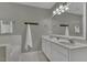 Bathroom featuring double sinks, white cabinetry, and combination shower and tub at 900 Finchurch Cir, Wake Forest, NC 27587