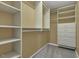 Walk-in closet with built-in shelving and drawer storage system, plus gray carpet flooring at 900 Finchurch Cir, Wake Forest, NC 27587