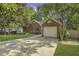 Traditional brick home featuring a two-car garage, established trees, and a well-manicured lawn at 900 Finchurch Cir, Wake Forest, NC 27587