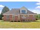 Expansive backyard view of brick home with a charming wooden deck and lush green lawn at 97 Rand Rd, Raleigh, NC 27603