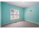 Empty blue bedroom with carpet and a bright window at 97 Rand Rd, Raleigh, NC 27603