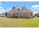 View of the home's exterior, featuring a brick facade, well-maintained lawn, and inviting deck at 97 Rand Rd, Raleigh, NC 27603