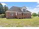 Charming backyard with a well-maintained lawn, brick home, and inviting wooden deck at 97 Rand Rd, Raleigh, NC 27603