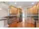 Traditional kitchen with stainless steel appliances, granite counters, wooden cabinetry, and hardwood floors at 97 Rand Rd, Raleigh, NC 27603