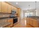 Well-lit kitchen featuring stainless steel appliances, stone countertops, and wooden cabinets at 97 Rand Rd, Raleigh, NC 27603