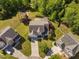 An aerial view of the home with manicured lawn, mature trees, adjacent homes, and a playground at 9701 Precious Stone Dr, Wake Forest, NC 27587