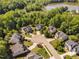 Aerial view of homes in a cul-de-sac, mature trees, and a pond at 9701 Precious Stone Dr, Wake Forest, NC 27587