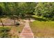 Backyard with wood steps to a fire pit with chairs and a cleared garden area at 9701 Precious Stone Dr, Wake Forest, NC 27587