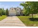 Charming yellow two-story home featuring a well-maintained lawn, two-car garage, and a welcoming front porch at 9701 Precious Stone Dr, Wake Forest, NC 27587