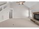 Spacious living room with carpet, fireplace with stone surround, ceiling fan, and staircase at 9701 Precious Stone Dr, Wake Forest, NC 27587