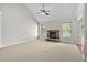 Spacious living room with carpet, fireplace with stone surround, ceiling fan, and multiple windows at 9701 Precious Stone Dr, Wake Forest, NC 27587